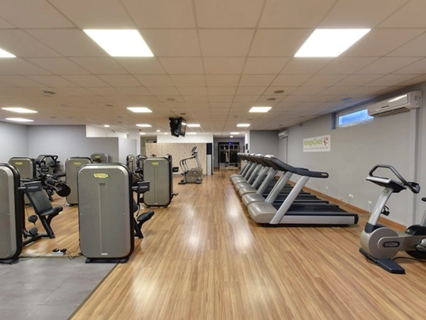 Een foto van een fitnesszaal met onder andere loopbanden en een hometrainer