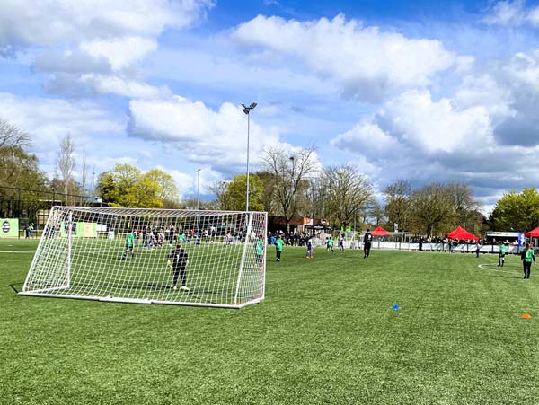 Een kijk op een voetbalwedstrijd op kunstgras bij de jeugd