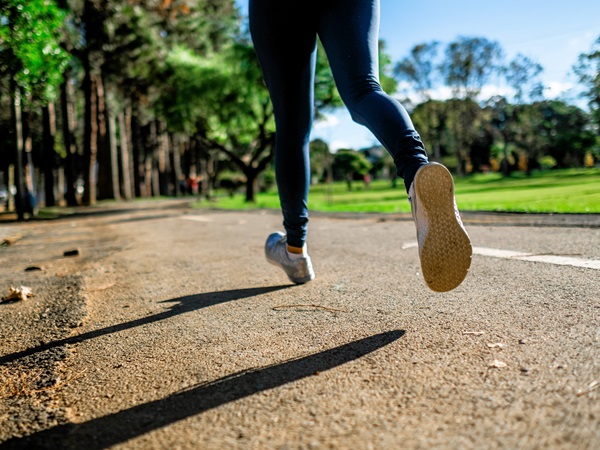 Een blik van een jogger die loopt op de weg met een lange broek